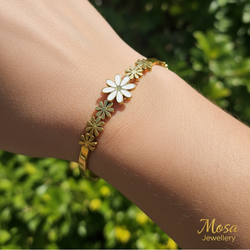 Bracelet with floral designs on a wrist against a blurred green background