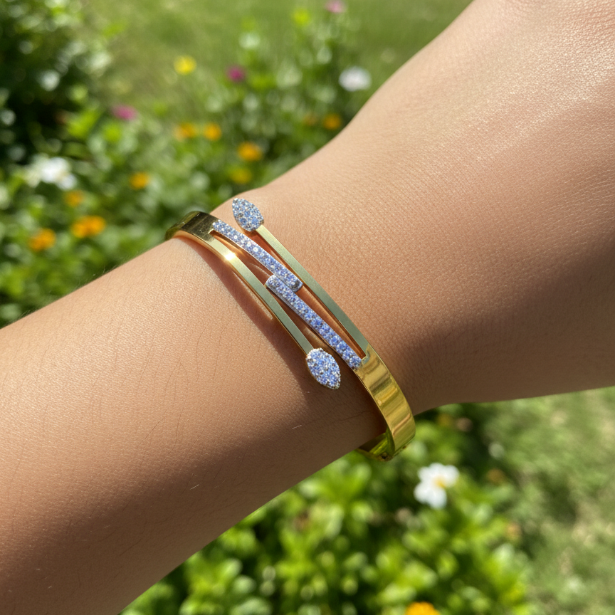 Gold bracelet with blue stones on a wrist against a green outdoor background