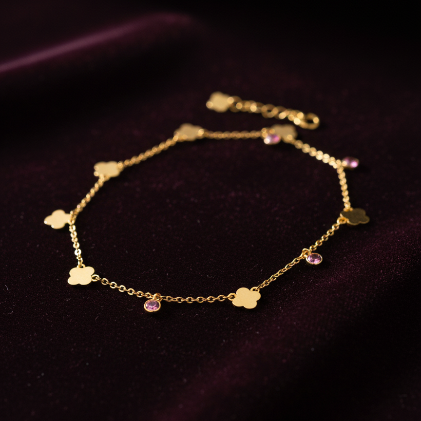 Gold anklet with heart-shaped charms on a dark background