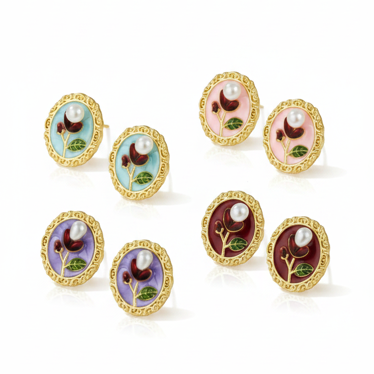 Set of gold earrings with colorful enameled designs on a white background