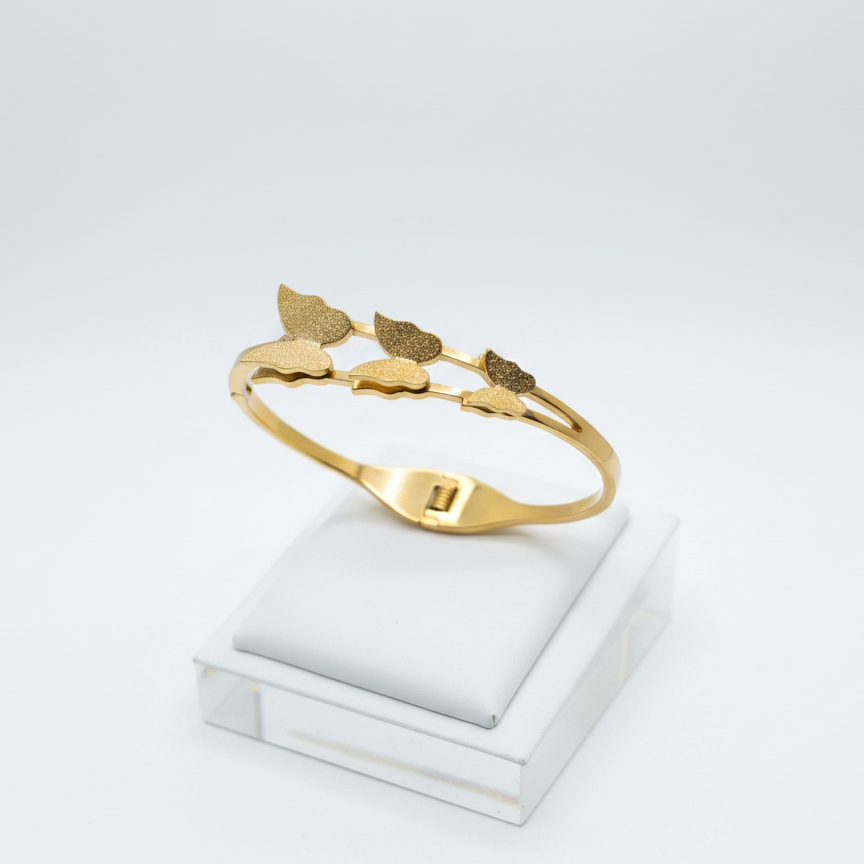 Gold bracelet with leaf-shaped charms on a dark background
